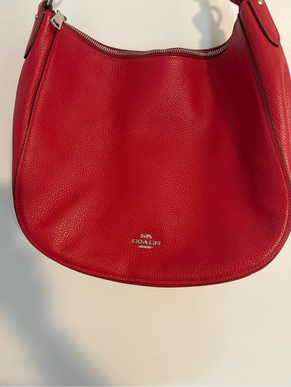 This is a vibrant, red Coach pebble, leather hobo shoulder bag